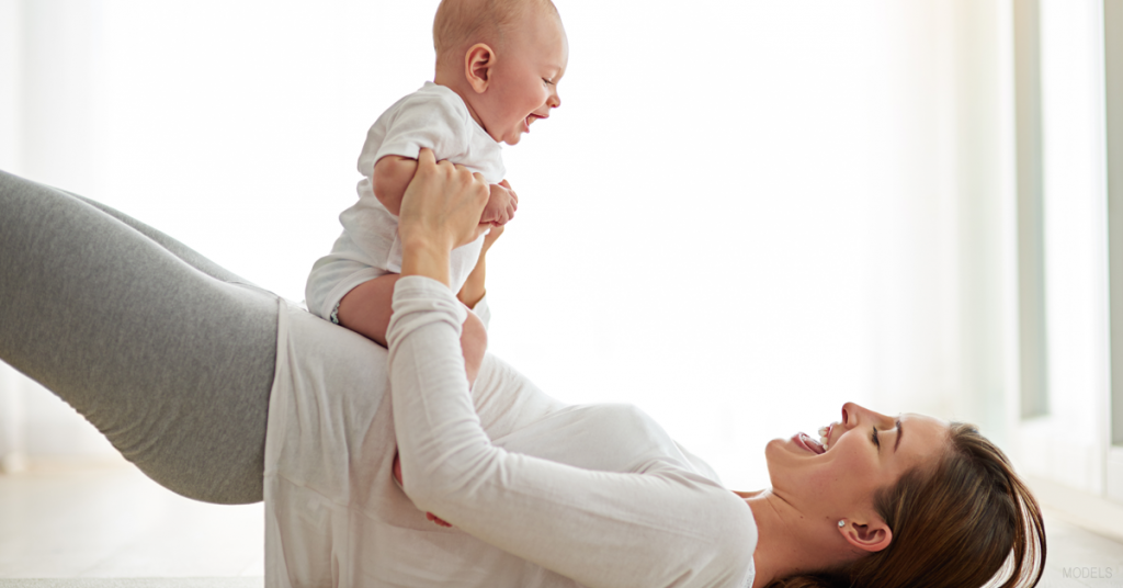 Woman laying on floor with her baby