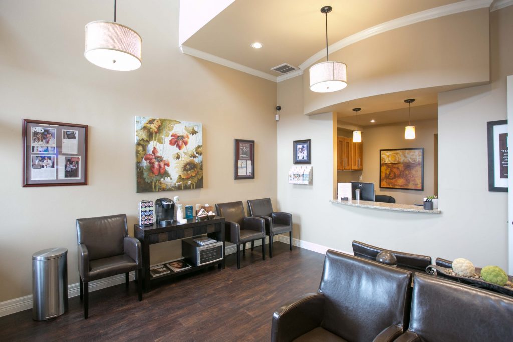 Round Rock plastic surgery reception area with dark wood floors and white, circular pendant lights.