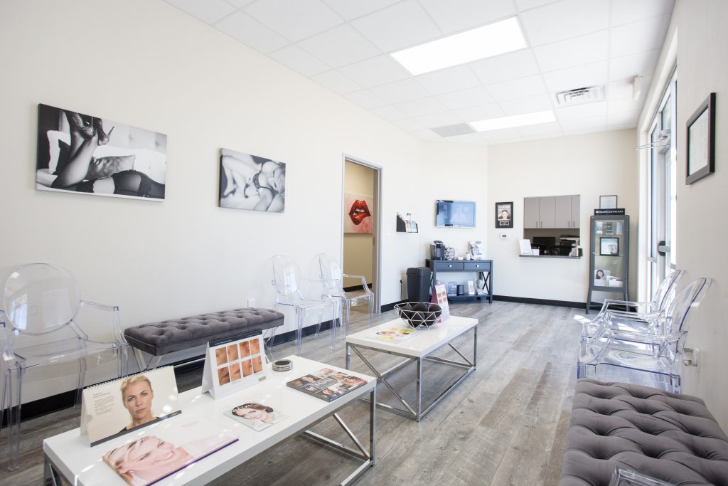 Austin, TX Office Waiting Area and Reception furnished with clear plastic chairs and tufted bench seats and black and white art on the walls