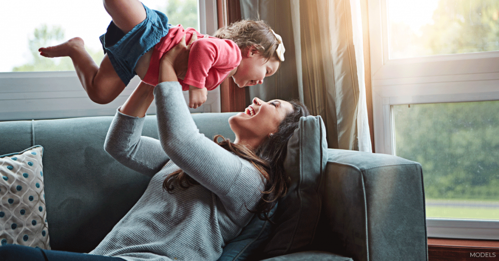 Mother smiling while playing with her child