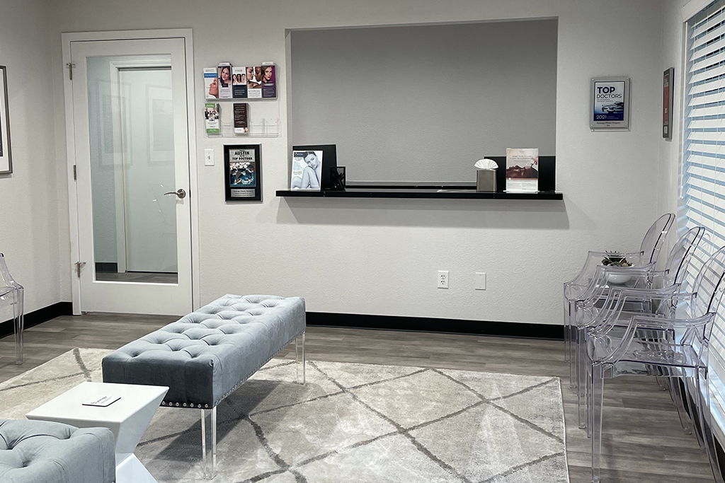 Reception area of West Lake Hills office furnished with clear plastic chairs and grey tufted benches.