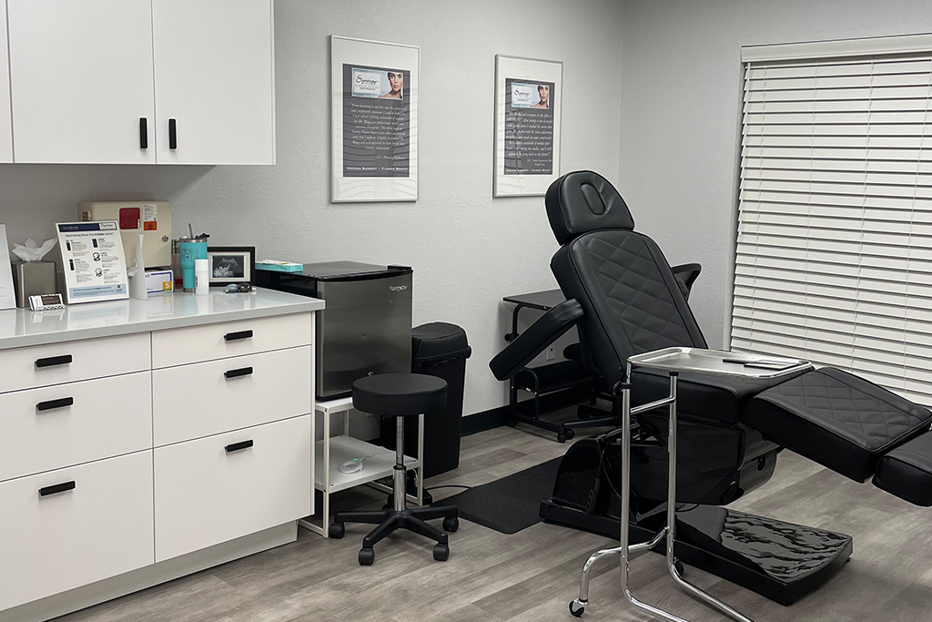 West Lake Hills med spa treatment room has a black reclining treatment chair with armrests. 