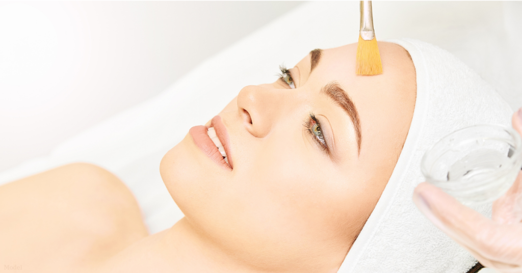 Woman receiving facial chemical peel treatment