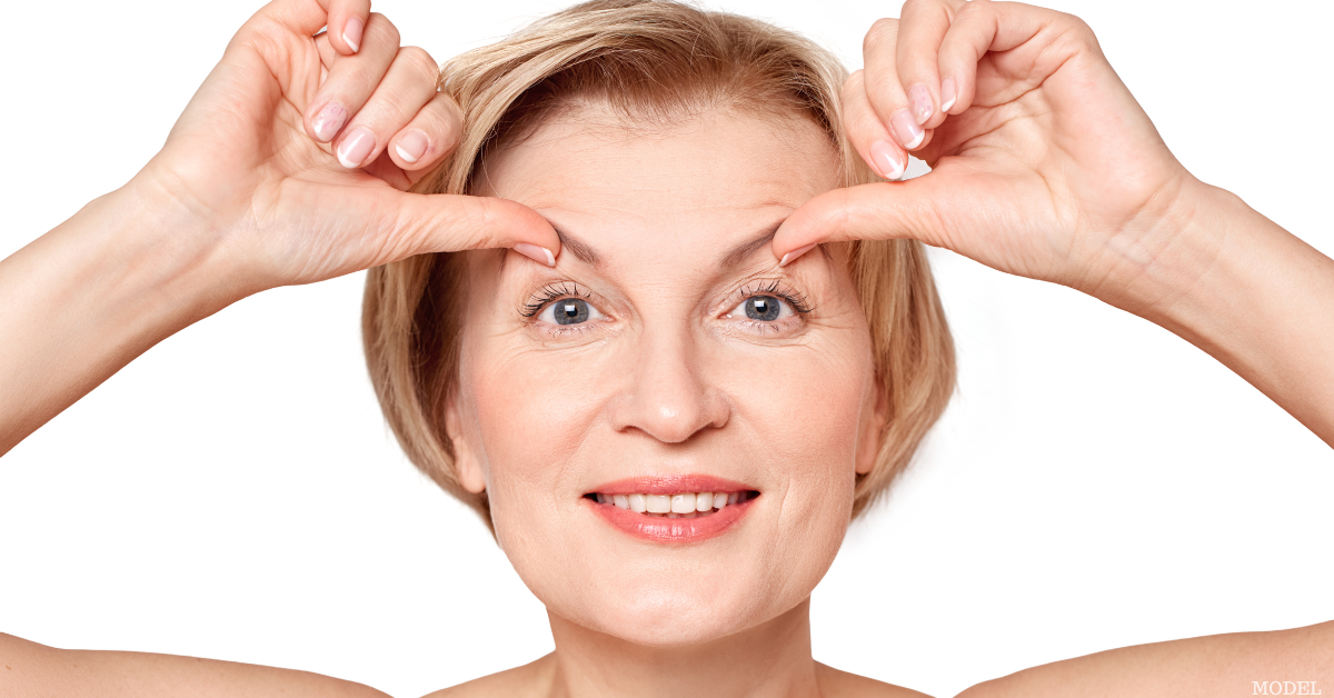 Middle aged woman lifting both of her eyebrows with her thumbs smiling (model)