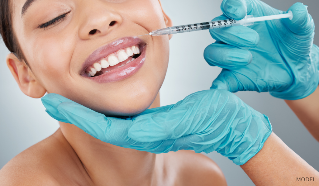 Woman smiling while receiving lip filler (model)