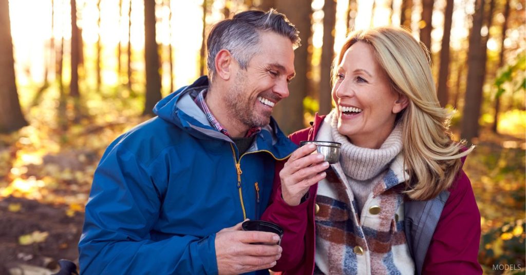 Mature couple with nice skin (models) sitting outside enjoying a beverage during the fall.