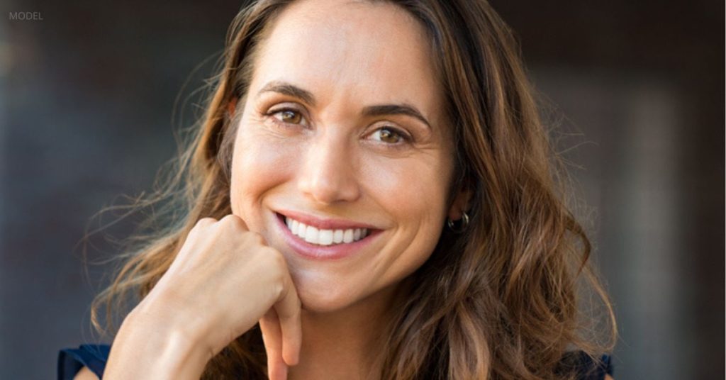 Woman with a youthful-looking face (model) smiling at the camera.