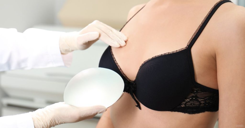 A woman in a bra is being examined by a doctor (model).
